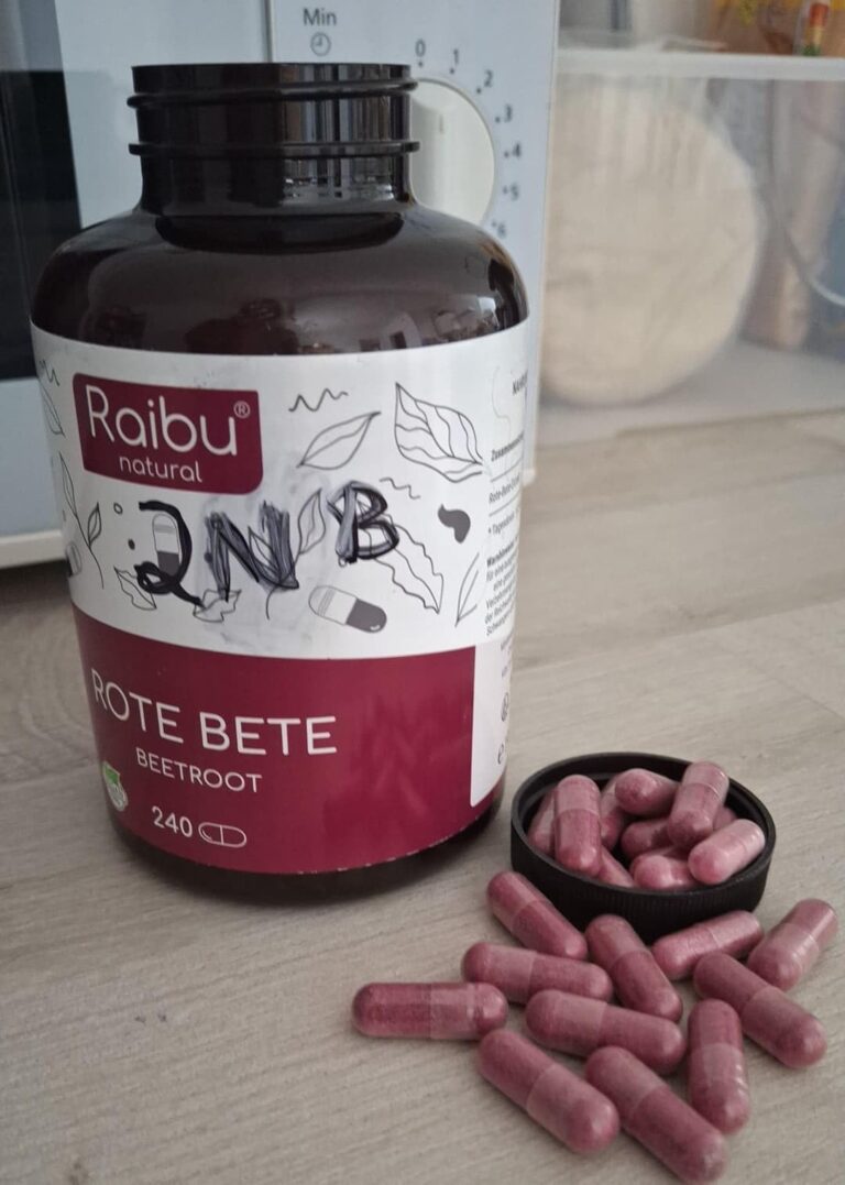Bouteille de compléments alimentaires, couvercle ouvert, avec des gélules dispersées sur une surface en bois. Un micro-ondes...
