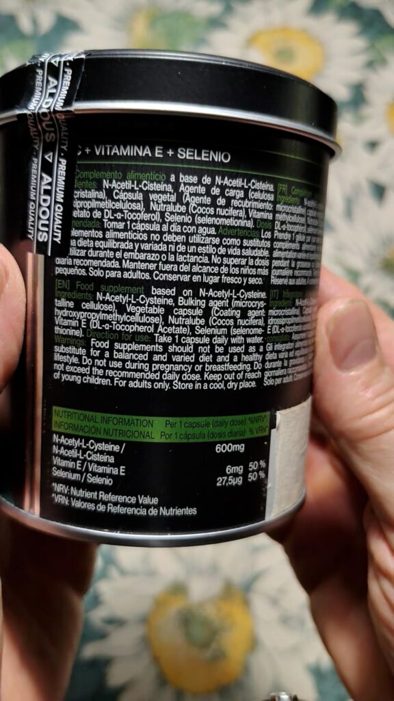 Gros plan sur les informations nutritionnelles et ingrédients au dos de la boîte de compléments alimentaires, tenue dans les...